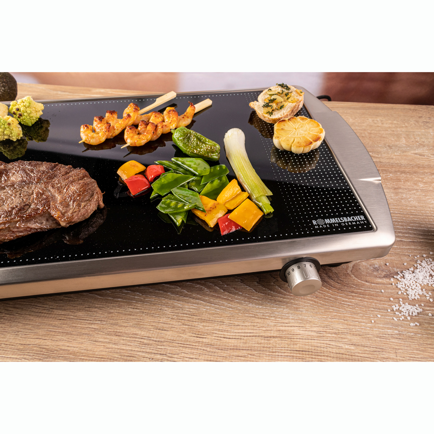 Biff, räkspett, grönsaker och vitlöksbröd grillade på Rommelsbacher glasgrill utomhus