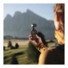 Hand som håller DJI Osmo Pocket 3 framför bergslandskap