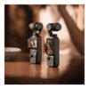 Två DJI Osmo Pocket 3 kameror på ett bord i varmt ljus