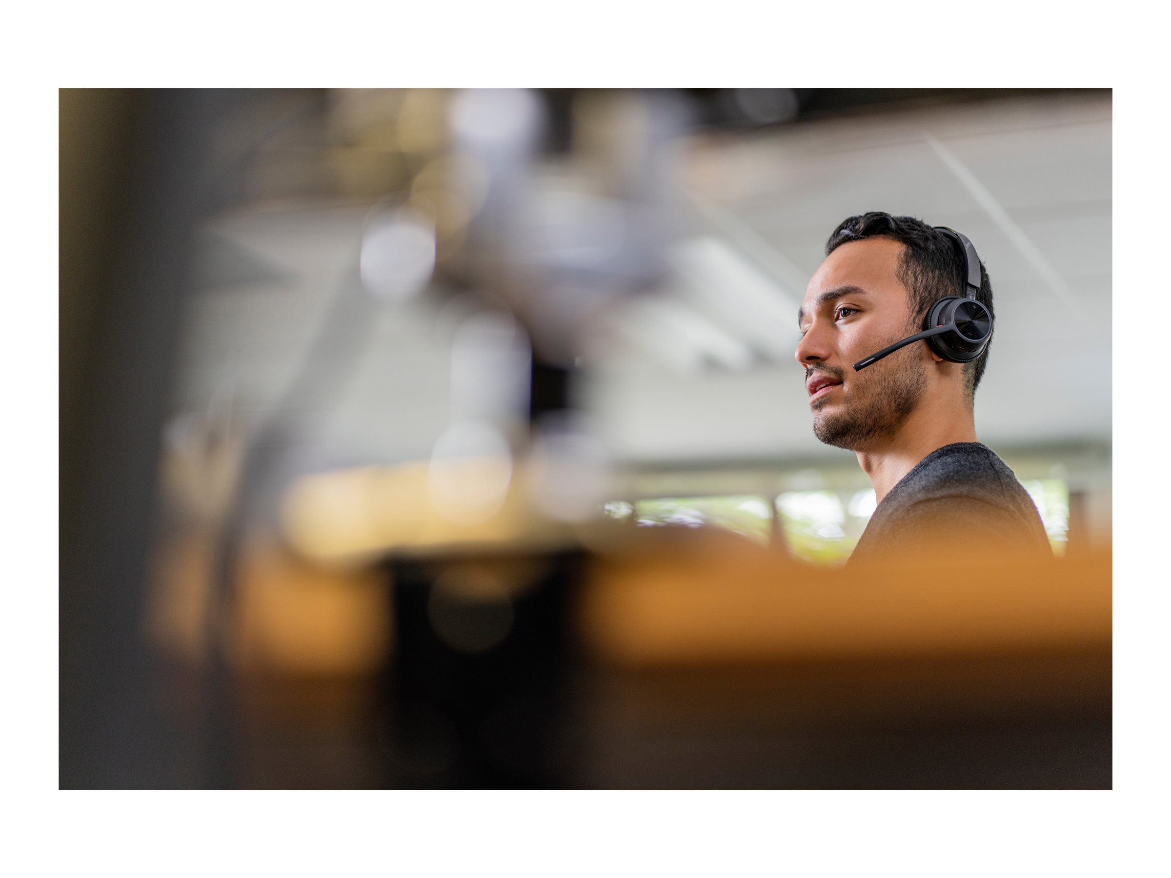 Person som använder Poly Voyager 4320 headset på kontoret