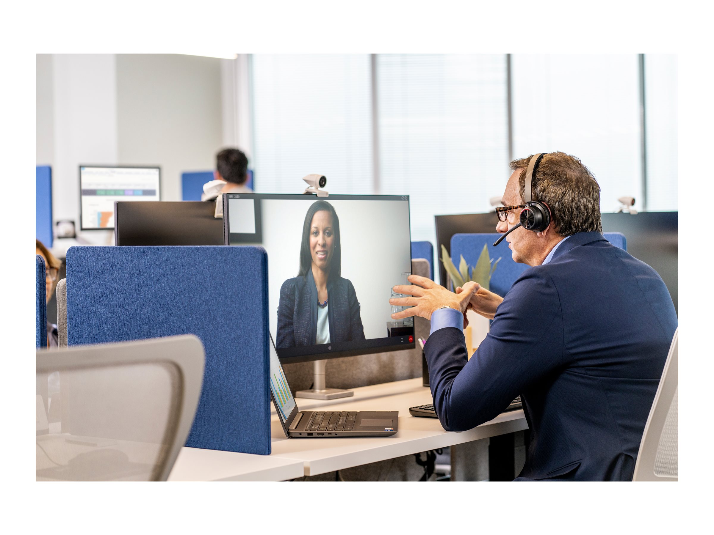 Man använder Poly Voyager 4320 headset i videomöte på kontor