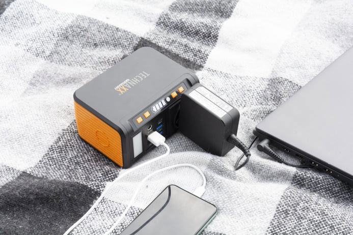 Technaxx TX-205 kraftpaket som laddar en mobiltelefon och en bärbar dator utomhus