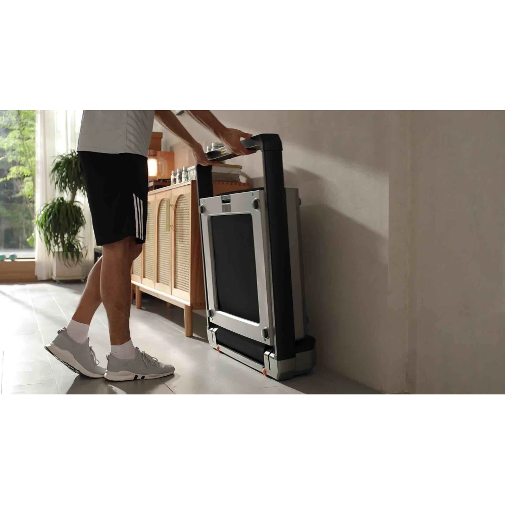 Hopfällt Xiaomi WalkingPad X23 löpband förvarat stående mot en vägg i hemmet
